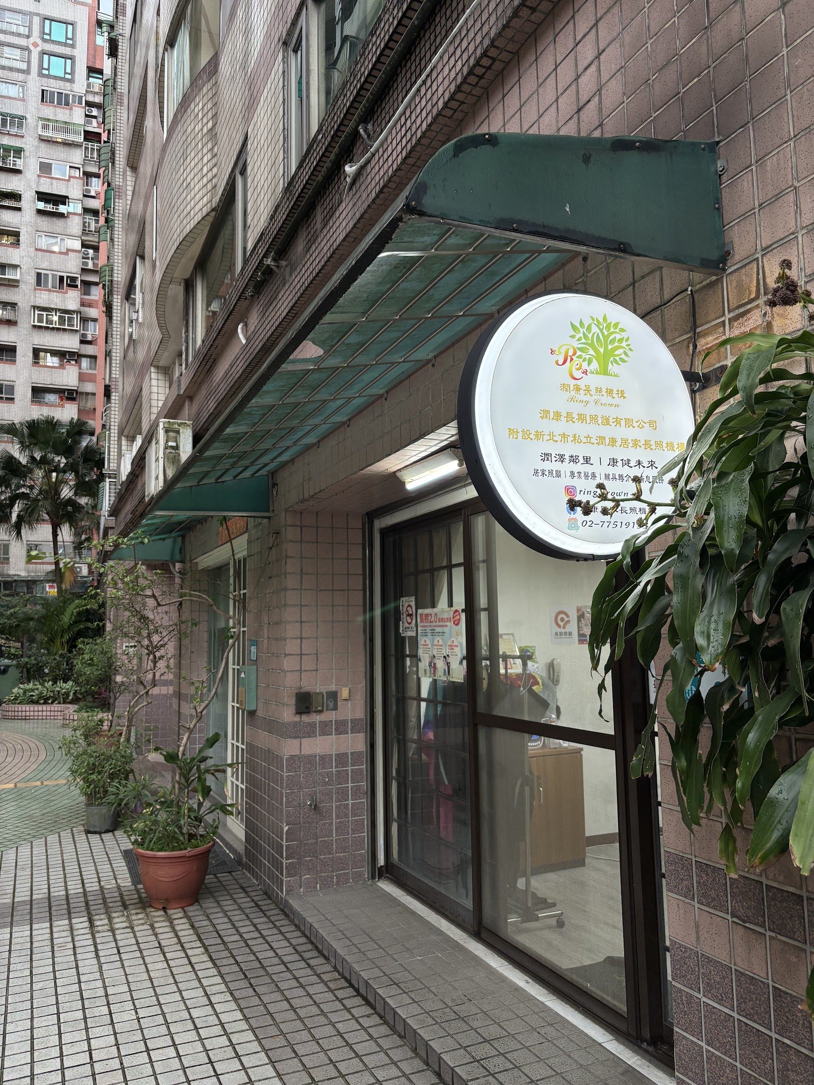 大樓一樓照護機構玻璃門與圓形招牌