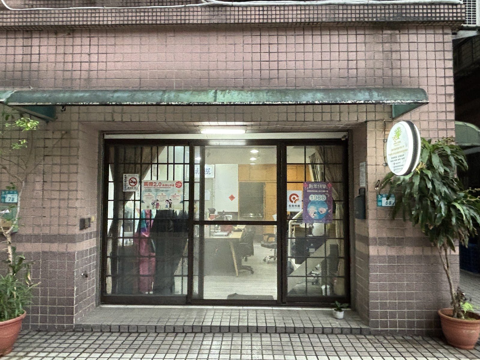 照護機構正面玻璃入口與兩側盆栽